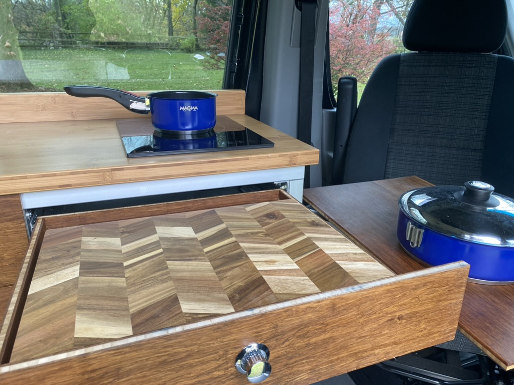 Custom wood drawer and induction cooktop inside a Keystone van