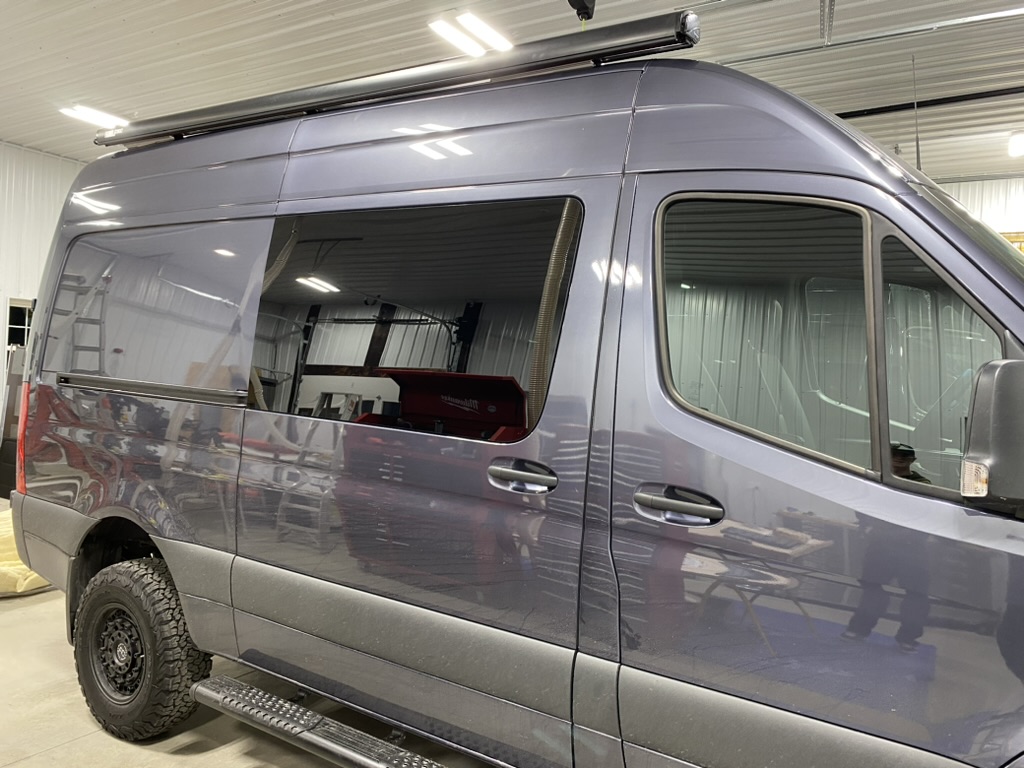 Finished gray Keystone camper van exterior inside the workshop